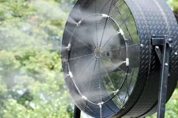 A black floor model fan with a misting kit attachment - An example of one of the best outdoor misting fans