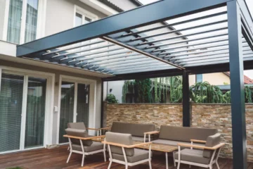 Black modern pergola attached to a house to cover a deck - An example of the best louvered pergola