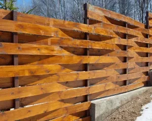 Horizontal privacy fence ideas using stepped wood slats and a concrete base.