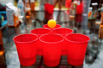 Red beer pong cups and yellow ball - Home bar games